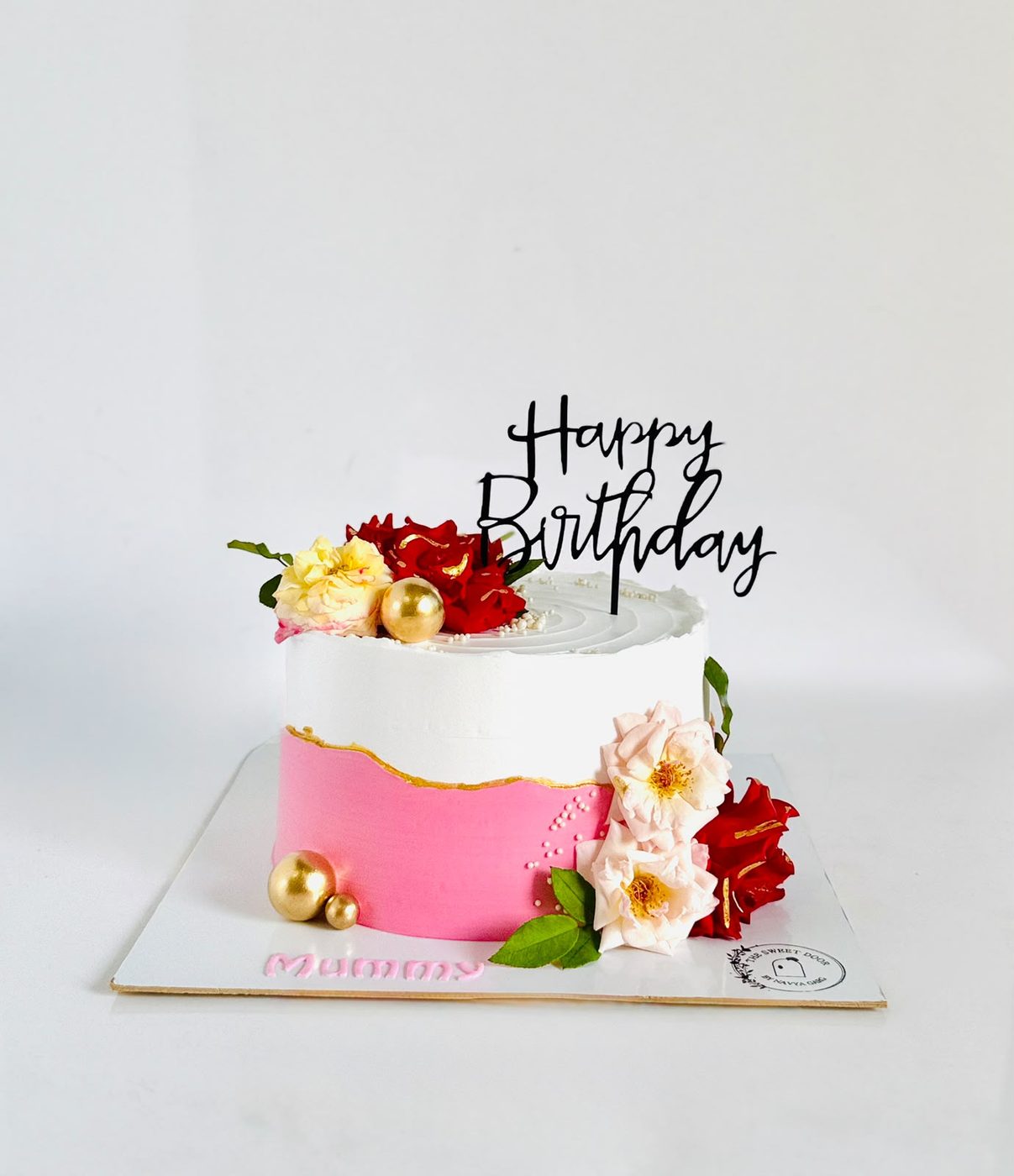 Pink and white birthday cake with fresh flowers